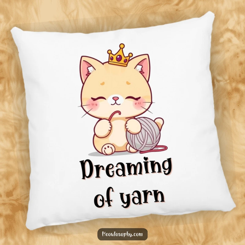Funny cat pillow with a cute character wearing a tiny crown, thoughtfully staring at a yarn ball, humorous home decor.