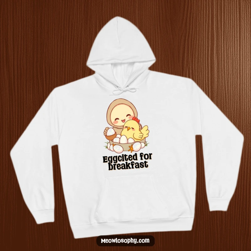 Funny hoodie with a smiling character gathering eggs from a drowsy, cartoonish chicken. Comfortable and humorous farm apparel.